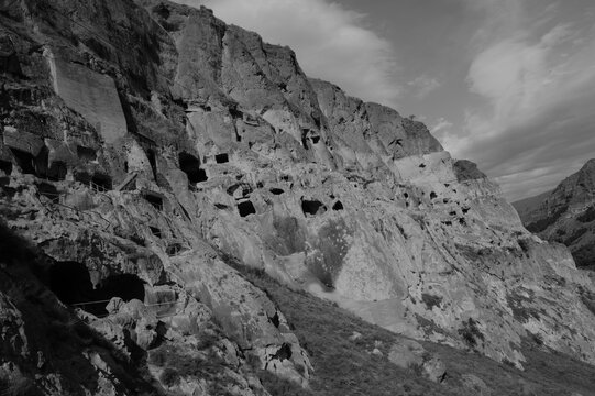 Habitations troglodytes creus&eacute;es dans une falaise de G&eacute;orgie au c&oelig;ur d'un paysage montagneux