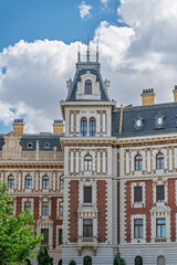 Pinnacled tower and arched windows of a former railway administration building against a cloudy sky in Budapest © Guillaume Angleraud