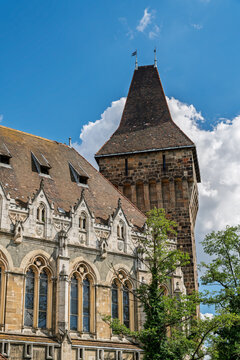 Romanesque corbelled tower beside a gothic gabled wing with tracery windows at Vajdahunyad Castle Budapest
