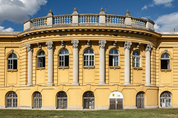 Symmetrical colonnade of the Széchenyi bath house facade seen under a bright summer sky in Budapest, Hungary © Guillaume Angleraud