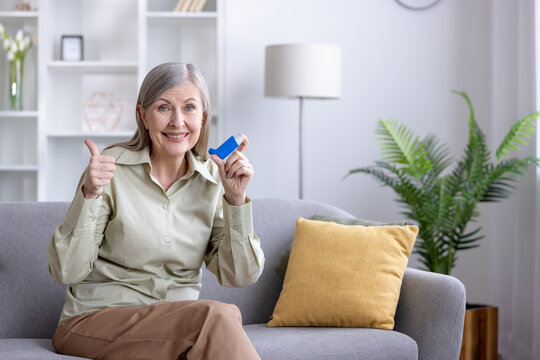 Senior woman showing inhaler and thumbs up for respiratory health