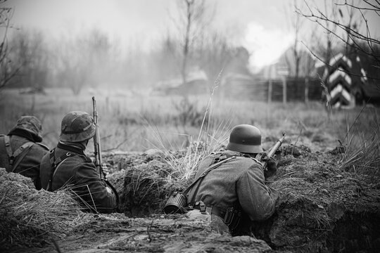 German Wehrmacht Infantry Soldiers In World War II Hidden Sitting With Rifles Weapons In An Ambush In Trench