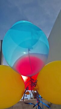Celebraci&oacute;n con globos de colores con helio en el cielo azul