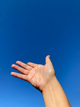 Mano aperta nel cielo blu