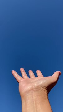 Mano aperta nel cielo blu