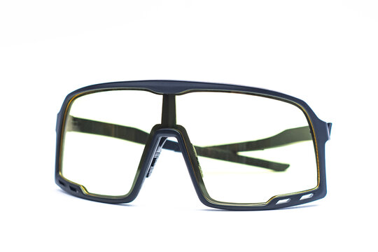 Modern protective safety glasses with yellow tint lenses isolated on white background. Industrial protective eyewear, eye protection gear, ballistic safety goggles, and work equipment concept.