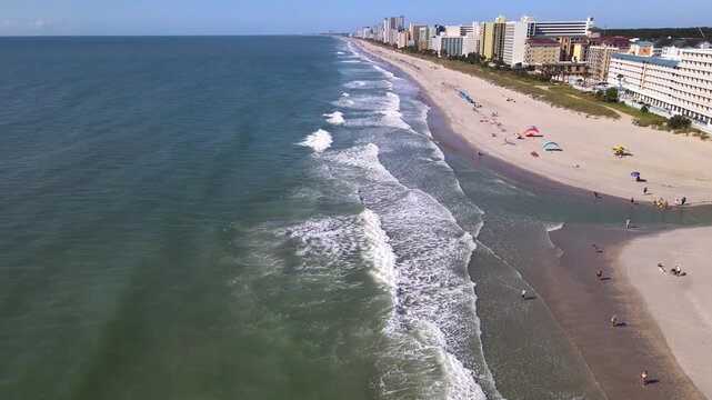  Foamy Atlantic breakers roll toward beachgoers along the sandy Myrtle Beach shoreline.
