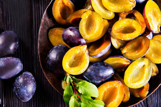 Plums on wooden background