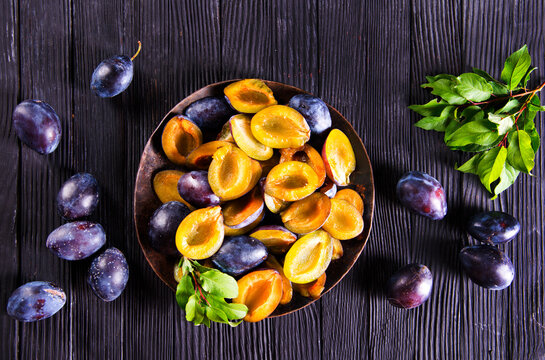 Plums on wooden background
