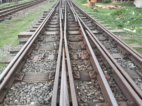 Multiple railway tracks converging with gravel bed