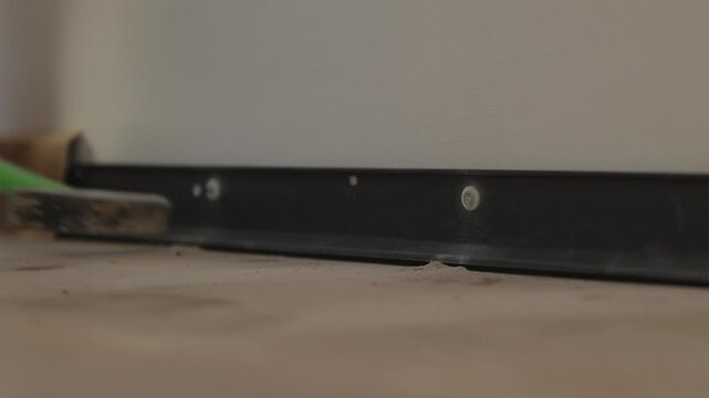 Hammering plastic wall anchor plug into drilled wall hole