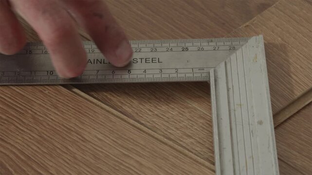 Steel ruler measurement tool being removed from work surface