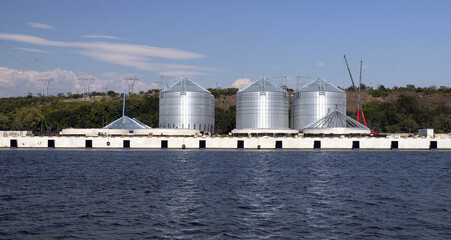 Grain silos along industrial pier at port © Lovec1