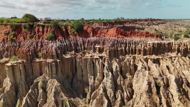 Panoramic aerial view of Miradouro da Lua featuring dramatic eroded rock formations, sharp clay spires, and striking red soil cliffs overlooking coastal landscape in Luanda Angola.
