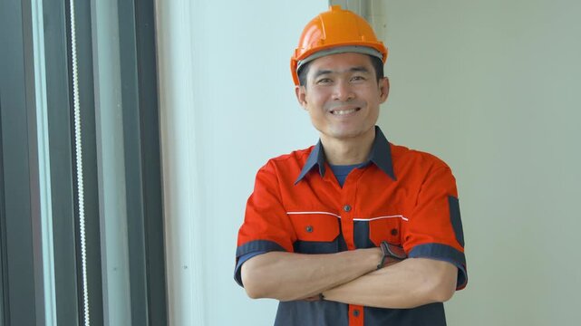 Portrait of a smiling construction worker wearing an orange hard hat and safety uniform