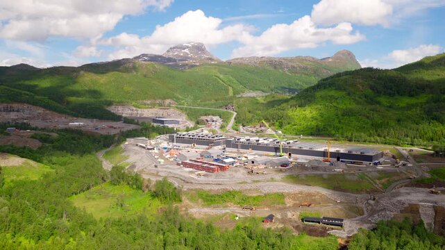 Massive data center construction site located in green mountain valley in Bjerkvik, Norway. Aerial backward