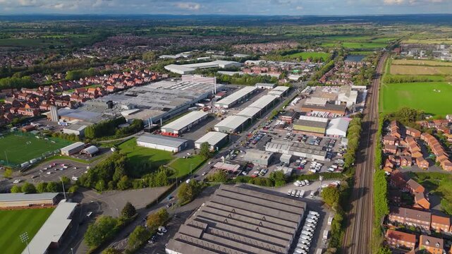 Aerial flight over industrial district and railway line near town