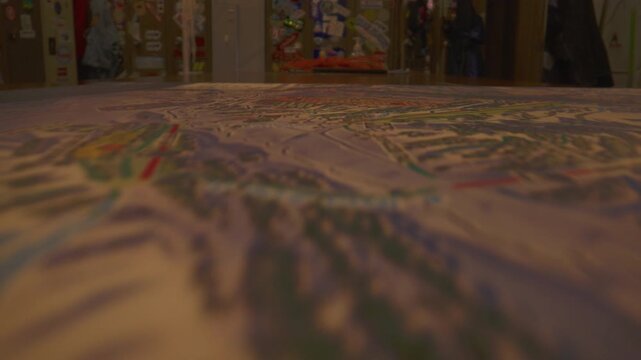 Dolly pushes forward across a ski resort map with trails drifting through shallow focus