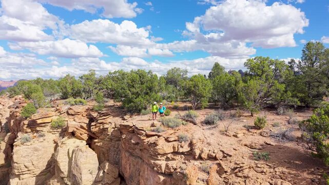Senior couple enjoys hiking on Gooseberry Mesa overlooking the landscapes of Zion National Park in Utah with beautiful views.