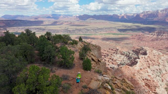 Aerial view of senior couple enjoying hiking on Gooseberry Mesa in Utah, taking in the views of Zion National Park and the landscape around them
