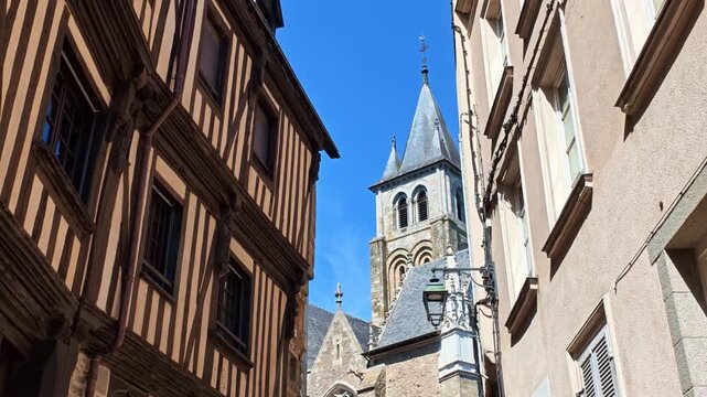 View of the historic Rue de la Trinite with half timbered houses and the Sainte-Trinite Cathedral in the background in Laval, France