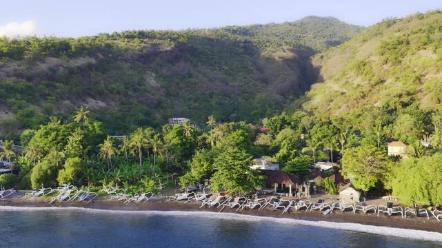 Traditional Jukung Fishing Boats Line The Dark Volcanic Sand Of Amed Beach In Karangasem, Eastern Bali, Indonesia. Aerial Drone Shot