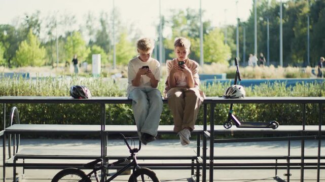 Two 10 Year Old Boys Phubbing and Using Smartphones in Park