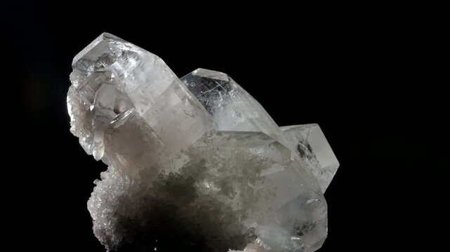 White Quartz crystals specimen rotating slowly against a black background. 
