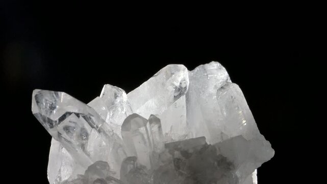 White Quartz crystals specimen rotating slowly against a black background. 