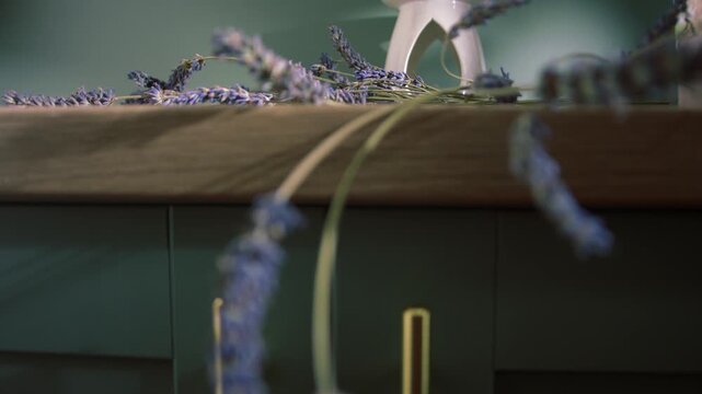 Lavender flowers and oil burner on home green cabinet