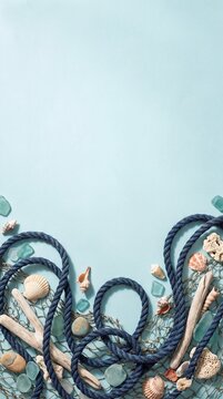 Blue nautical rope and fishing net border with seashells on light blue background