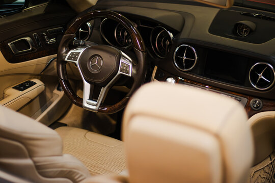 Krakow, Polska - September 05, 2026: Mercedes Benz luxury car interior with leather seats, wood steering wheel, dashboard gauges, center console, and illuminated circular air vents in cabin