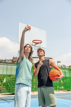 vertical Teenage friends taking selfie on basketball court