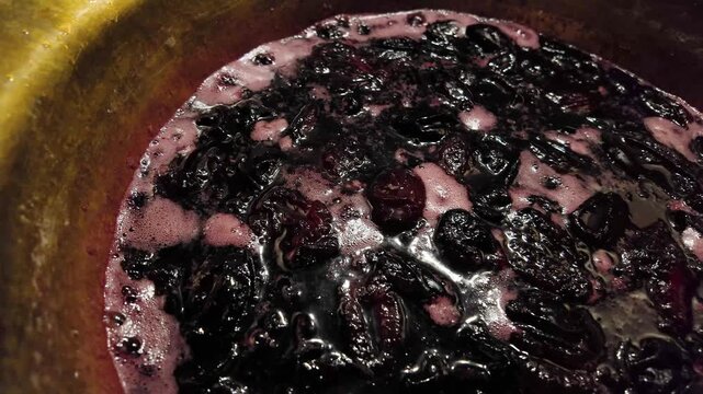 Plum jam boiling in a copper preserving pan. cooking plum jam 