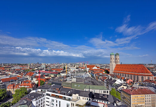 High angle wide panorama of Munich city skyline with Frauenkirche cathedral under blue sky, Germany