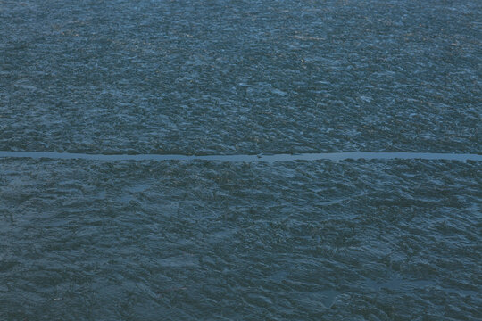 Horizontal crack line dividing frozen ice textures on a lake surface