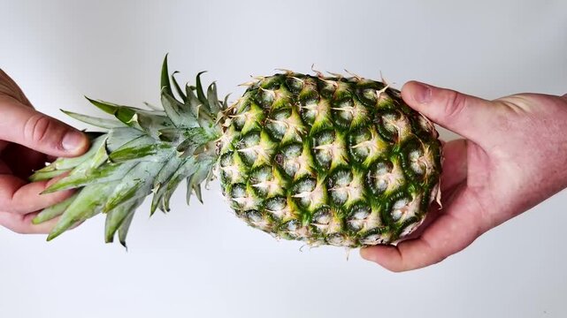 Two hands hold a whole pineapple with green leaves against a plain white background, repeated in a vertical three part sequence