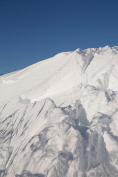 Massive white snowdrift texture against a clear blue winter sky