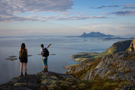 Two Hikers on Mountain Ridge Pointing at Landegode Island Norway