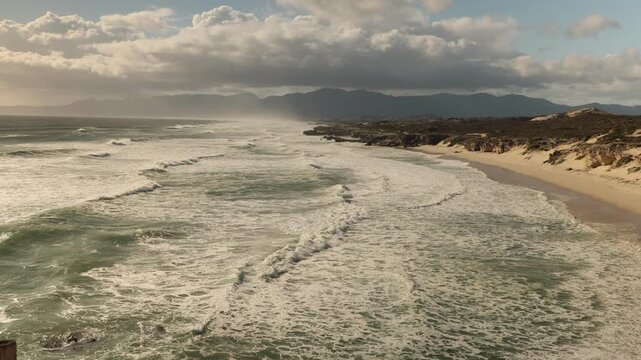overhead view of massive wave sets rolling into Walker Bay Nature Reserve beach, South Africa