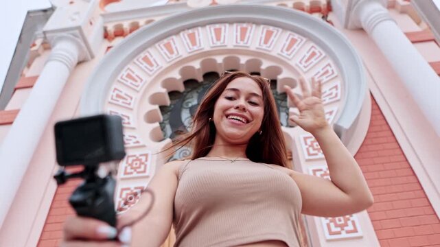 Young female influencer vlogging with an action camera outdoors