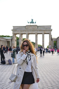 Woman posing in sunglasses before Brandenburg Gate in Berlin
