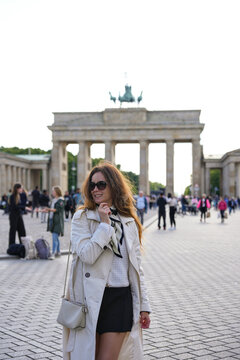 Woman in sunglasses posing before Brandenburg Gate in Berlin