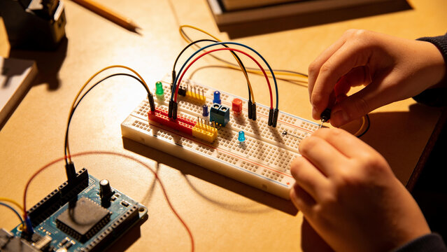 Macro of young hands learning electronics in a STEM class