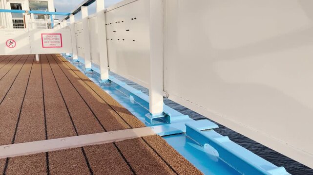 A blue metal step rests on a cruise ship deck above Lake Ladoga. The sturdy frame ensures safety. The calm water creates a serene and quiet feeling.
