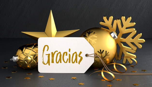 Christmas - Gift Tag with the Spanish "Thanks" message "Gracias" on a black stone background leaning against gold colored christmas ornaments around.