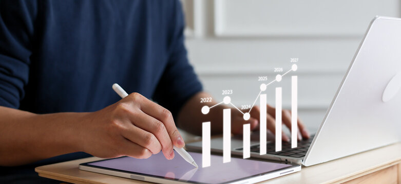close up manager businessman write and think strategy of business profit with virtual statistic graph for new year 2027 target and financial forecasting in office room concept