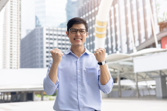 close up young asian businessman raised hand with happiness feeling after complete and get a new job position in city for new career path concept