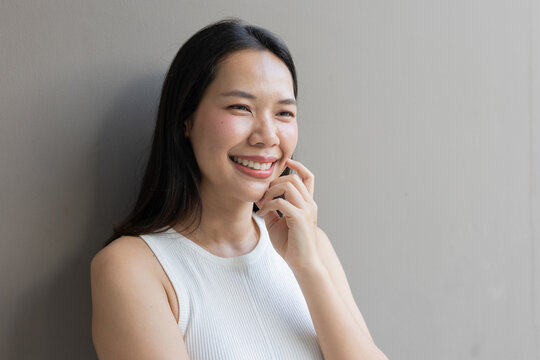 close up beautiful asian woman smile and beauty teeth and happy feeling on gray color background for veneer and invisalign treatment concept
