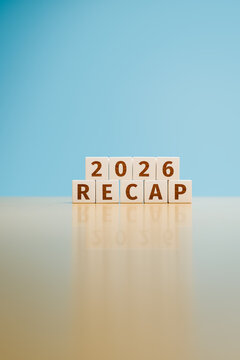 Wooden toy cubes forming the text "2026 RECAP". Concept for recapitulating what happened in the year 2026. Magazine cover format with copy space